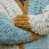 Detail pleteného svetru z vlny The Wave Wool v barvách Natural, Aquamarin a Mustard